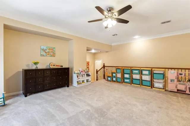 wooden floor with a ceiling fan and a dresser
