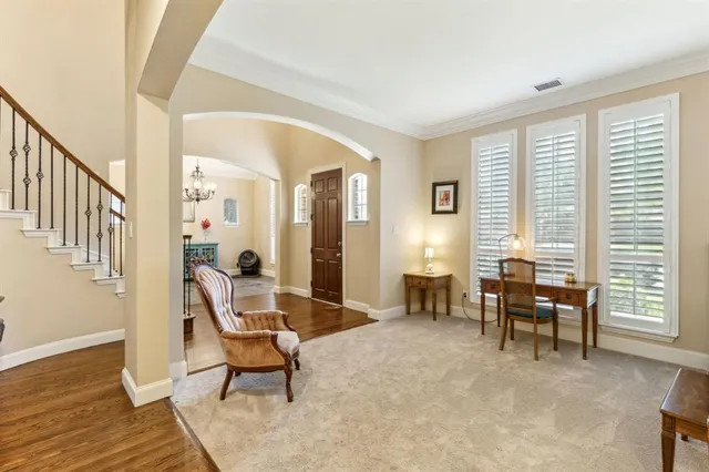 a living room with furniture and two large window
