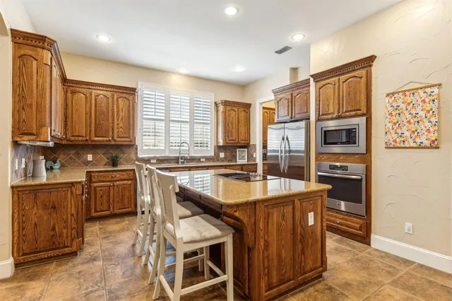 a dining hall with stainless steel appliances granite countertop a stove and a refrigerator