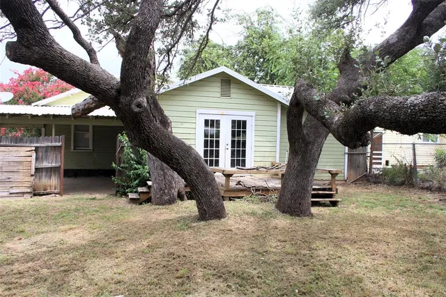 a tree in front of a white house