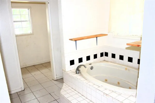 a bathroom with a bathtub and a window