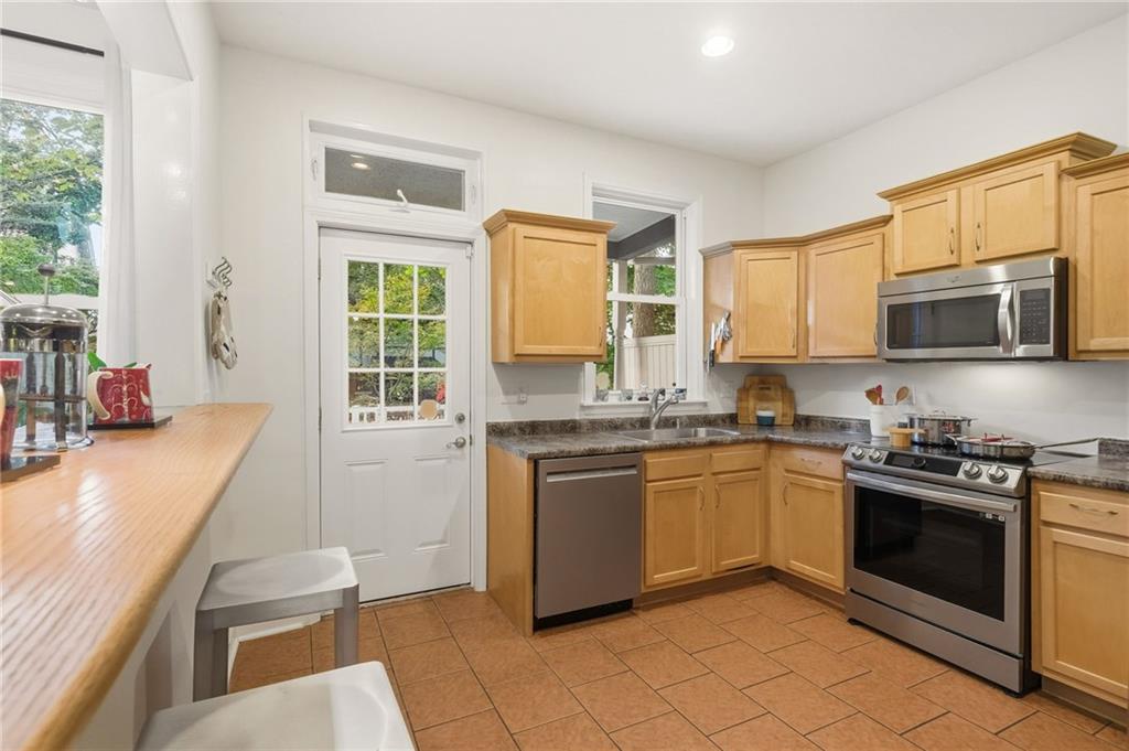 1127 Portland Street Pittsburgh, PA 15206 - Photo 13 of 50 a kitchen with stainless steel appliances granite countertop a stove a sink and a microwave