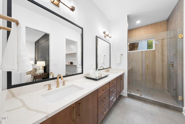 a bathroom with double vanity sinks and a shower