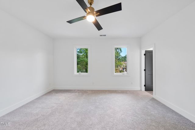 an empty room with windows and ceiling fan