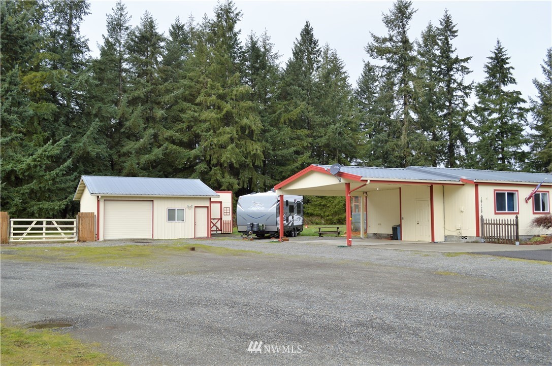 19129 Loganberry Street Southwest Rochester, WA 98579 - Photo 3 of 25 a view of a house with a yard and large trees