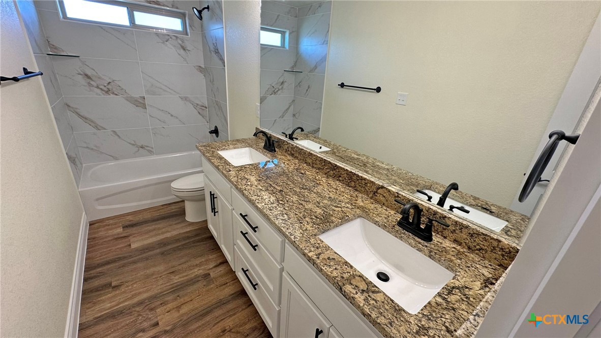 4237 Cool Basin Road Kempner, TX 76539 - Photo 21 of 36 a bathroom with a granite countertop sink a mirror and shower