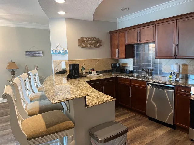 a kitchen with stainless steel appliances granite countertop a table chairs sink and cabinets
