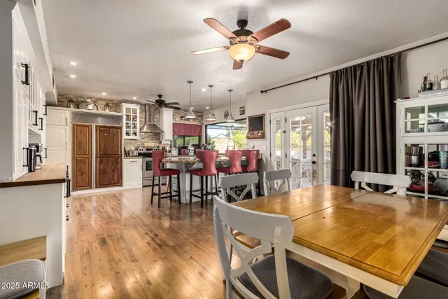 a large kitchen with stainless steel appliances refrigerator dining table and chairs