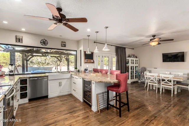 a living room with stainless steel appliances furniture and a kitchen view