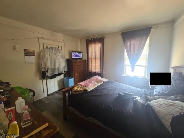 a bedroom with a bed window and flat screen tv