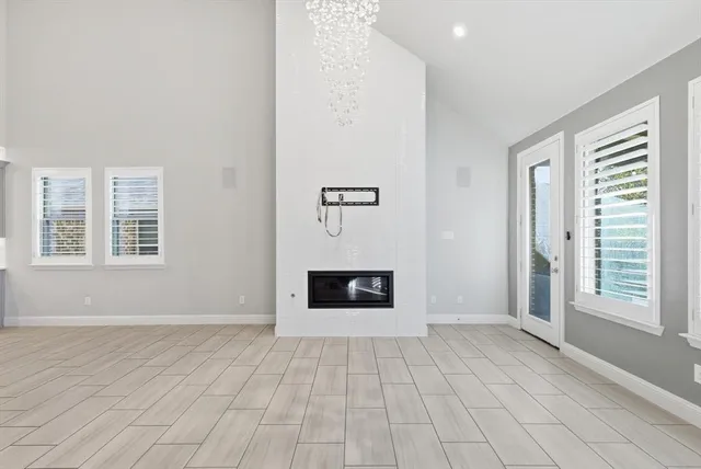 an empty room with windows and fireplace