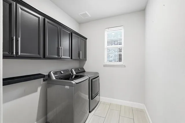a kitchen with granite countertop white cabinets and black appliances