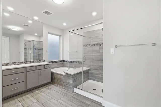 a large bathroom with a double vanity sink and mirror with shower