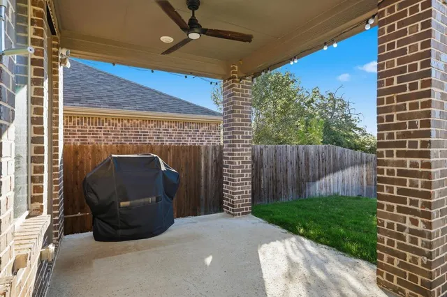 a view of backyard with wooden fence and a barbeque
