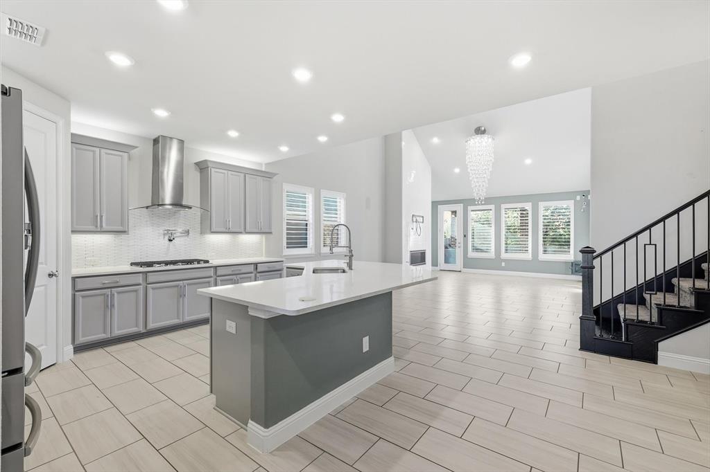 2114 Stanhill Drive Corinth, TX 76210 - Photo 7 of 40 a kitchen with stainless steel appliances granite countertop a stove a sink dishwasher a refrigerator and white cabinets with wooden floor