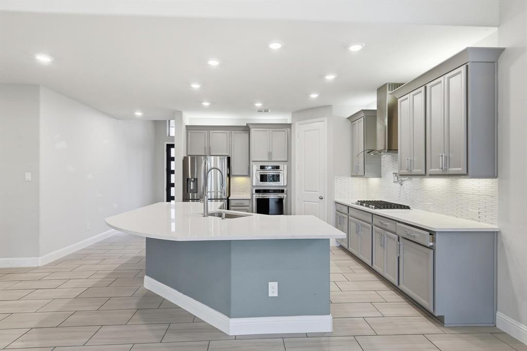 2114 Stanhill Drive Corinth, TX 76210 - Photo 8 of 40 a large kitchen with kitchen island a sink a stove a refrigerator and a cabinets