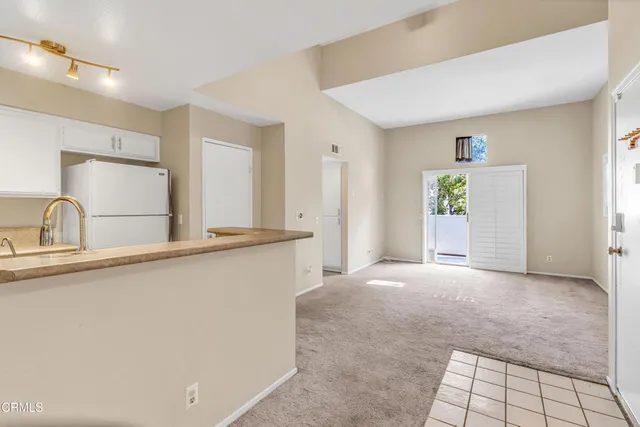 a view of an empty room with window and bathroom