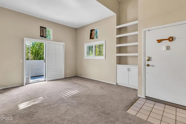 a view of an empty room with closet and windows