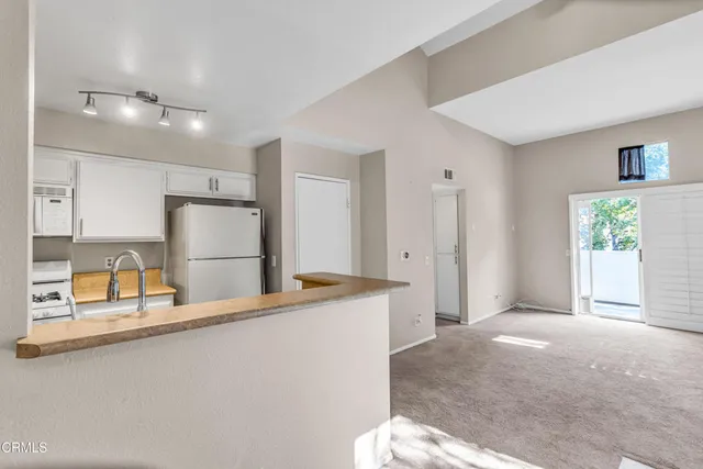 a view of a kitchen with refrigerator and windows