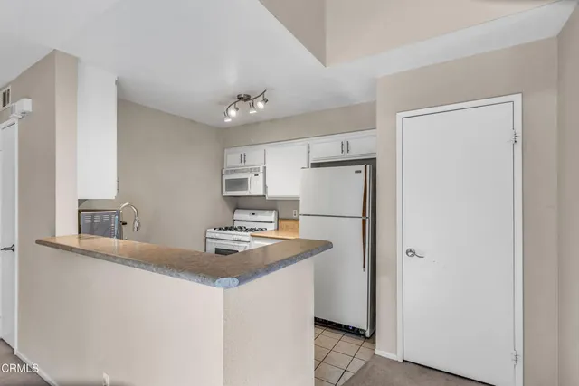 a kitchen with kitchen island a sink appliances and a counter top space