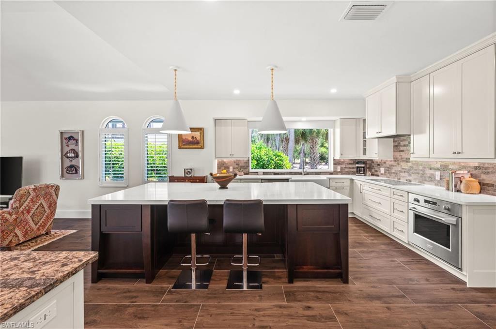 2003 Duke Drive Naples, FL 34110 - Photo 10 of 45 Gourmet kitchen with GE Monogram appliances, custom cabinetry, and expansive center island with seating
