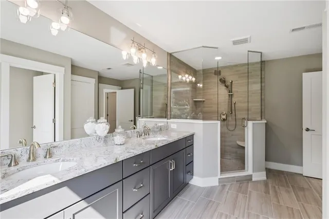 a bathroom with double vanity sinks and a shower