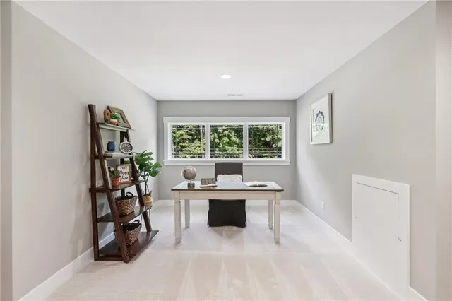 a work room with furniture a rug and a window