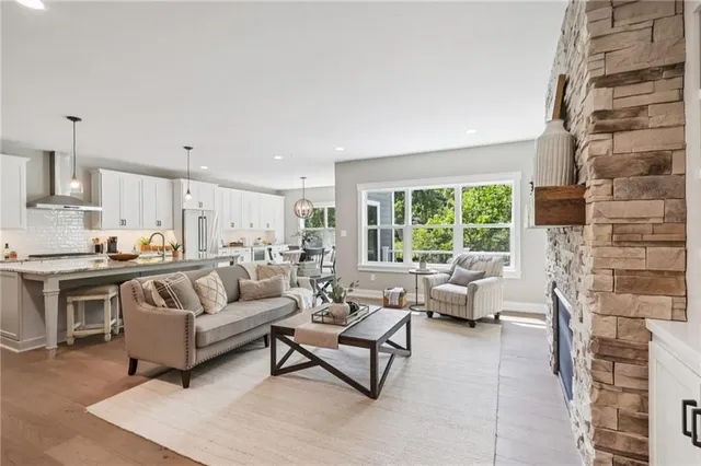 a living room with fireplace furniture and a large window
