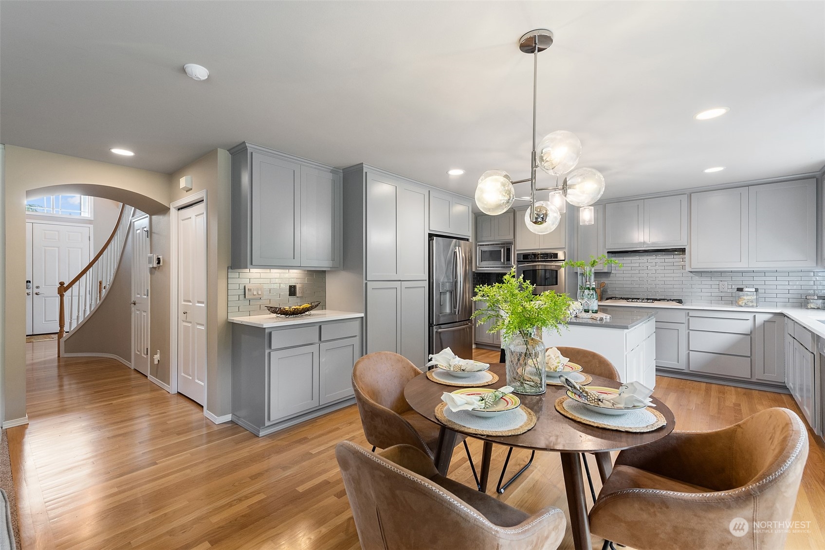 4411 240 Place Southeast Bothell, WA 98021 - Photo 14 of 36 a kitchen with a dining table cabinets appliances and wooden floor