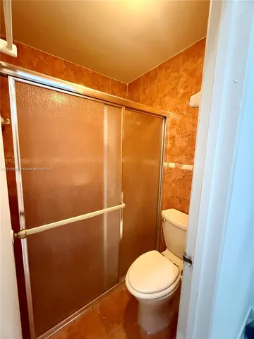 a bathroom with a toilet and a shower