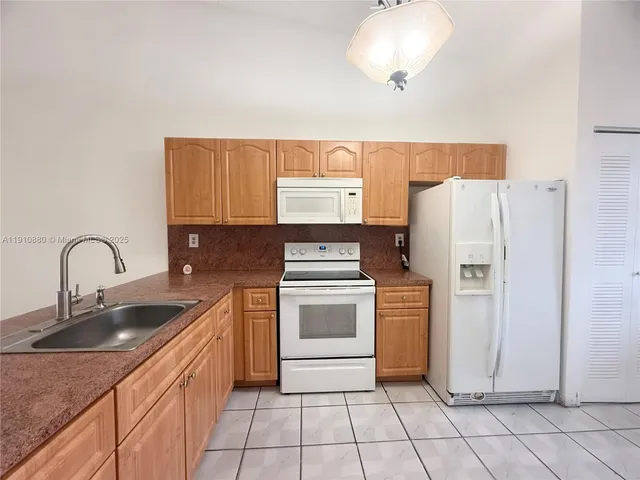a kitchen with appliances a sink and cabinets