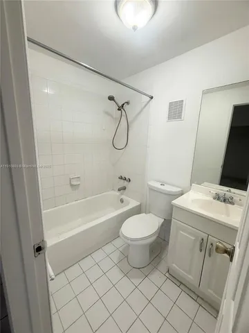 a bathroom with a granite countertop toilet a sink and a bathtub