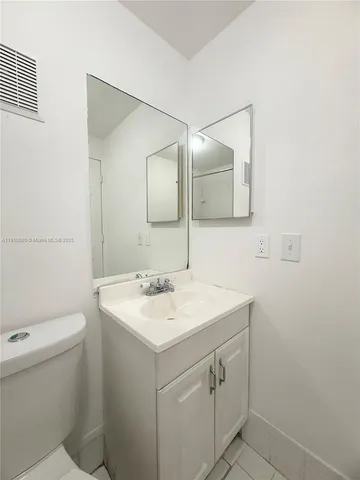 a bathroom with a sink toilet and mirror
