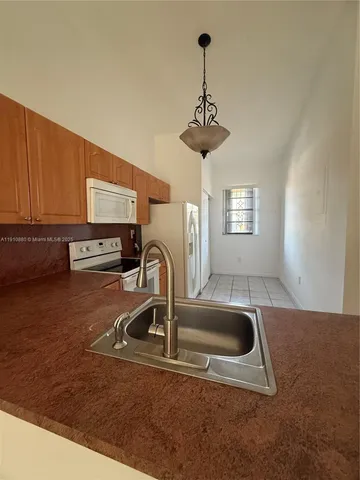 a kitchen with a sink a counter cabinets and appliances