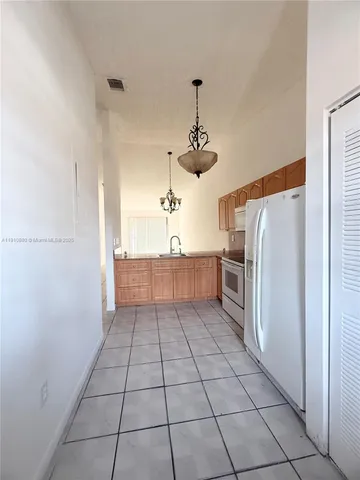 a kitchen with granite countertop a refrigerator and a stove top oven