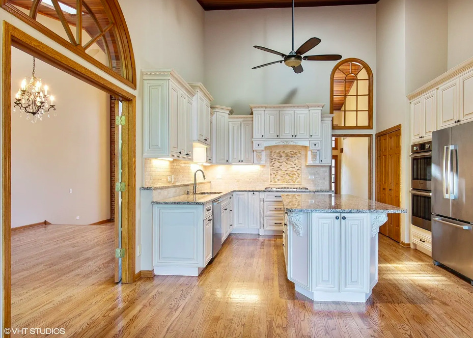 1551 Edgewood Road Lake Forest, IL 60045 - Photo 5 of 16 a kitchen with stainless steel appliances granite countertop a refrigerator a sink dishwasher a stove and a dining table with wooden floor