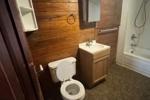 a bathroom with a toilet sink and mirror