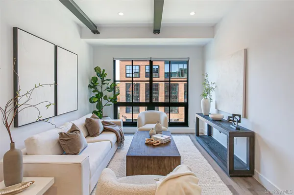 a living room with furniture large window and potted plants