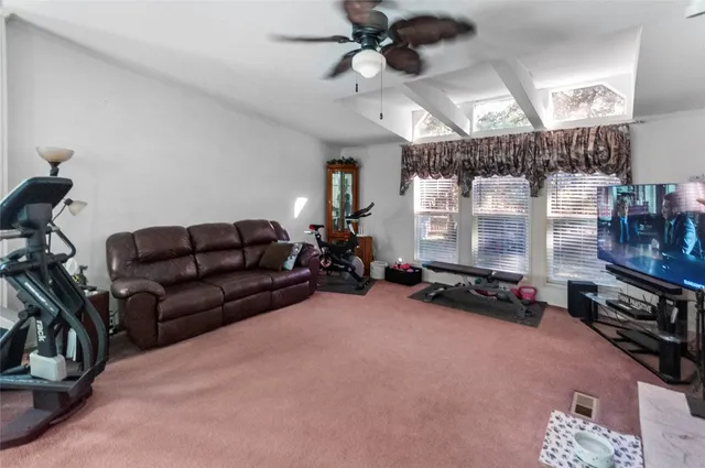 a living room with furniture a flat screen tv and a window