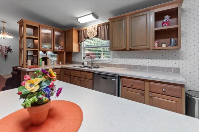 a kitchen with stainless steel appliances granite countertop a sink dishwasher and cabinets with wooden floor