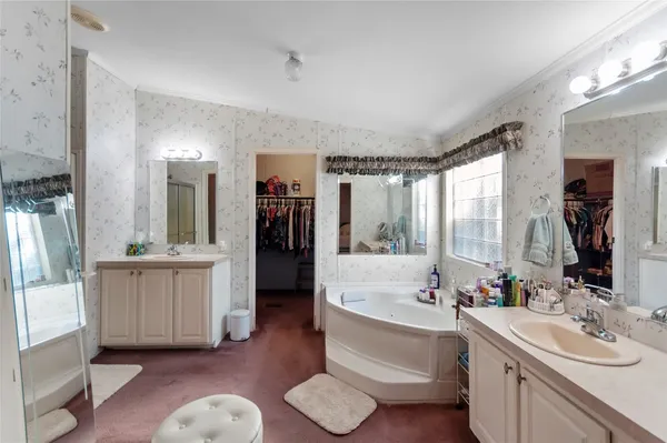a bathroom with a double vanity sink mirror and bathtub