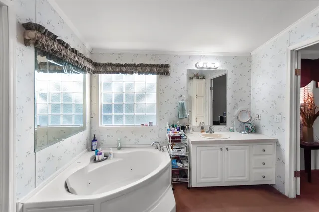 a bathroom with a double vanity sink bathtub and window