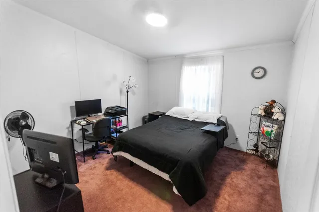 a bedroom with bed and a flat tv screen