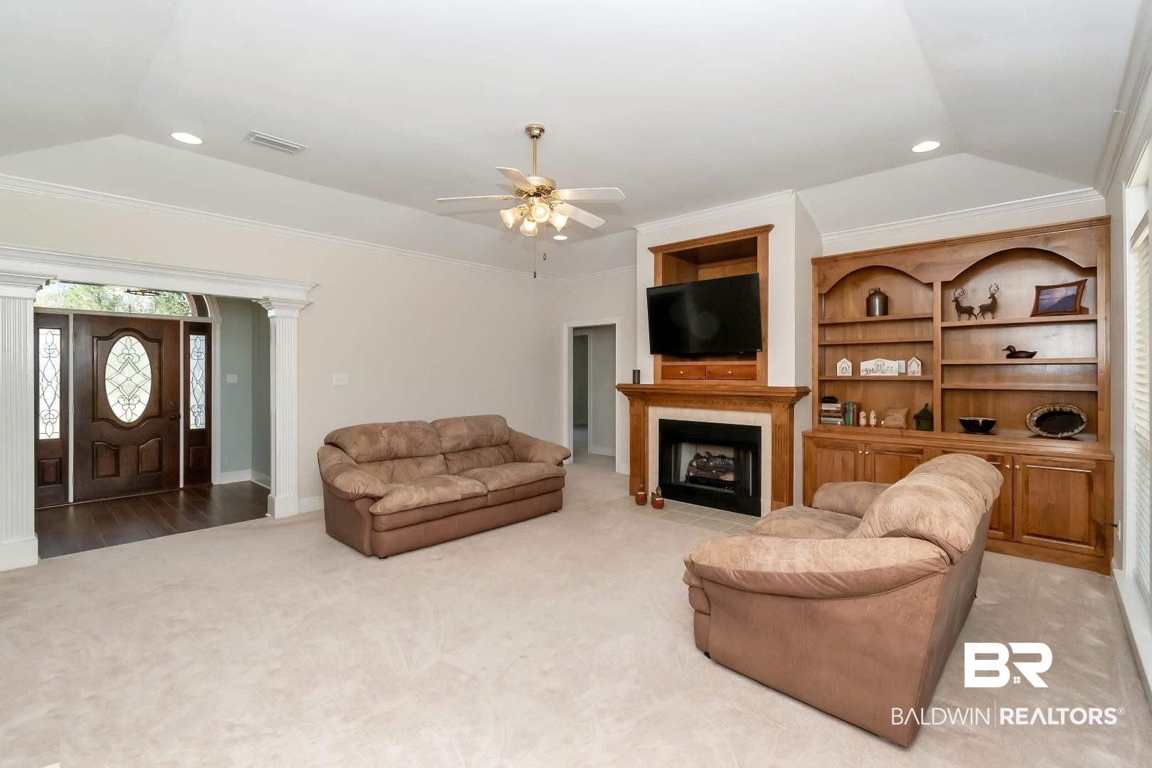 6090 Celeste Road Saraland, AL 36571 - Photo 6 of 38 Living room with a tile fireplace, light carpet, lofted ceiling, ceiling fan, and ornamental molding