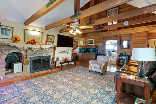 a kitchen with stainless steel appliances kitchen island granite countertop a refrigerator a stove a sink a dining table and chairs with wooden floor