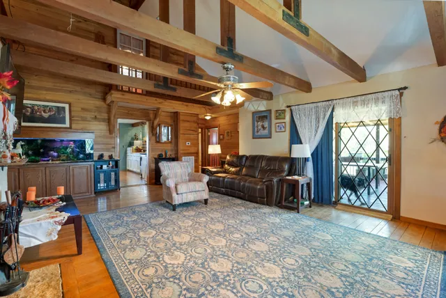 a kitchen with stainless steel appliances kitchen island granite countertop a stove top oven a sink a dining table and chairs with wooden floor