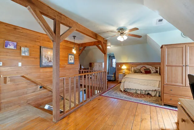 a bedroom with a bed dresser and a large mirror