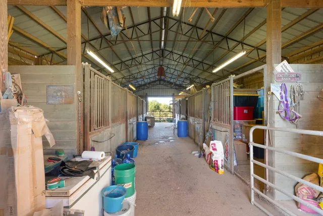 an aerial view of a houses with outdoor space and trees all around