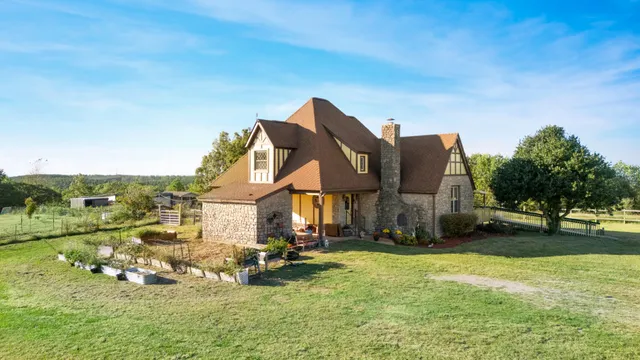 a view of a big house with a big yard and large trees
