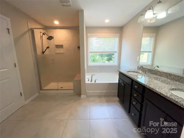a bathroom with a granite countertop sink a toilet and shower